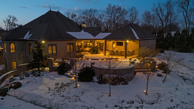 snow covered house with brick siding