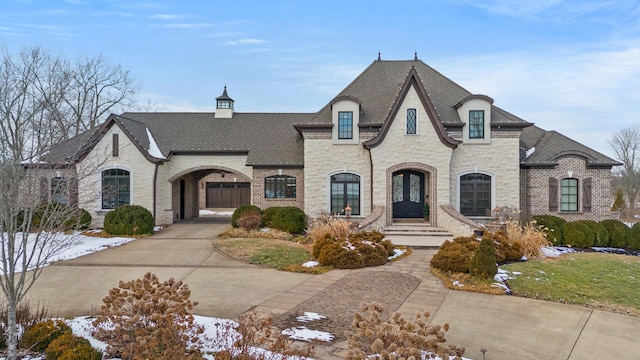 french provincial home with stone siding