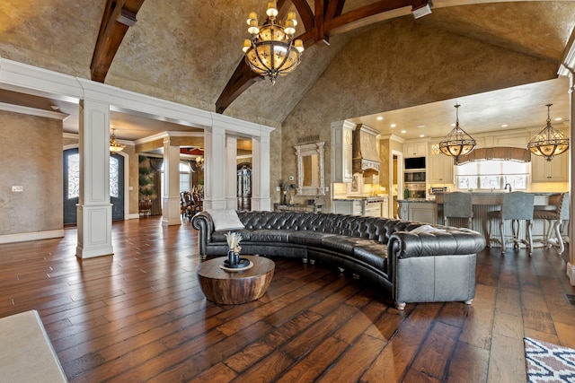 living room featuring high vaulted ceiling, ornate columns, a chandelier, dark wood-style floors, and beam ceiling