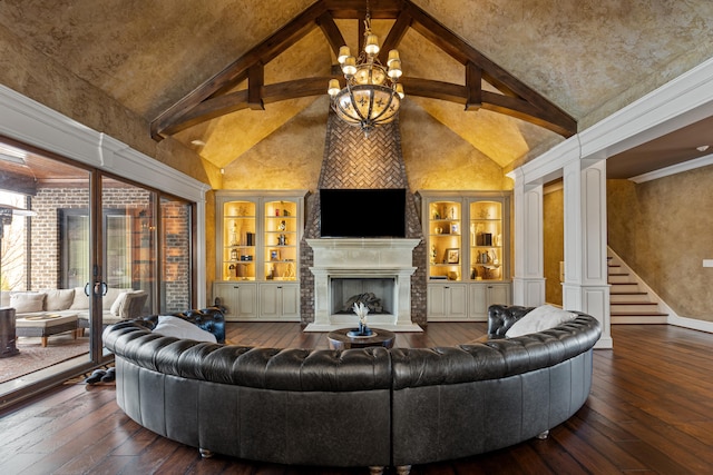 living room with wood-type flooring, a fireplace with raised hearth, high vaulted ceiling, a chandelier, and stairway