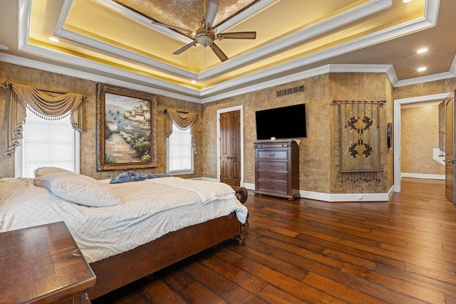 bedroom featuring ornamental molding, a tray ceiling, wood-type flooring, recessed lighting, and baseboards