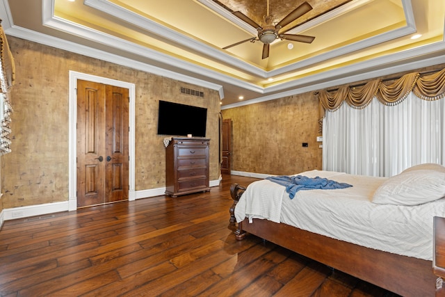 bedroom with a raised ceiling, ornamental molding, hardwood / wood-style floors, baseboards, and ceiling fan