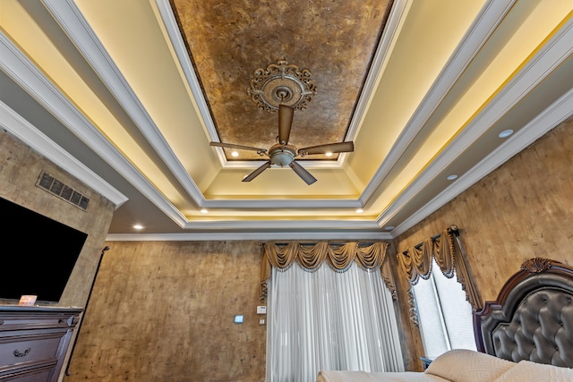 detailed view of crown molding, ceiling fan, and a tray ceiling