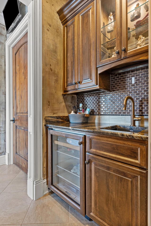 bar area with a sink, beverage cooler, decorative backsplash, and light tile patterned flooring