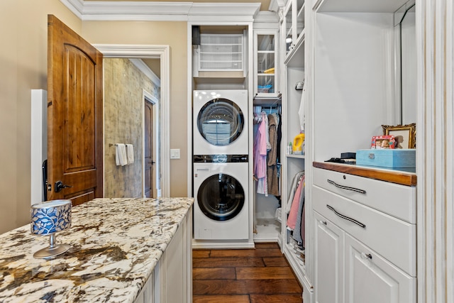 clothes washing area with stacked washer and clothes dryer, dark wood-style floors, and ornamental molding