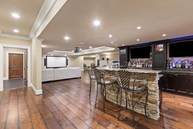 indoor wet bar with crown molding, recessed lighting, dark wood-style floors, baseboards, and a tray ceiling