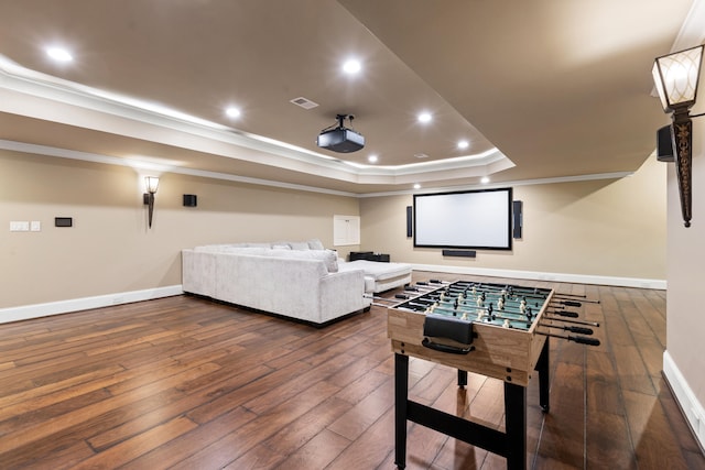 home theater with crown molding, wood-type flooring, a raised ceiling, baseboards, and recessed lighting
