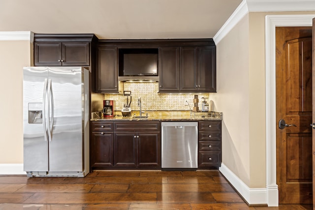 kitchen featuring appliances with stainless steel finishes, stone counters, dark wood-style floors, decorative backsplash, and crown molding