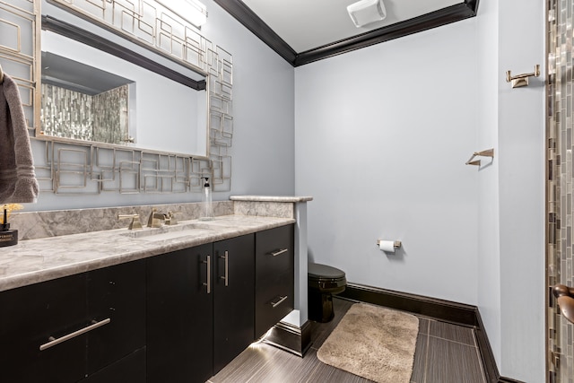 bathroom with ornamental molding, toilet, and vanity
