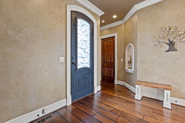 foyer entrance with dark wood finished floors, ornamental molding, and baseboards