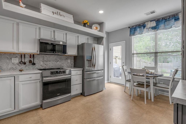kitchen featuring stainless steel appliances, decorative backsplash, light countertops, white cabinets, and recessed lighting