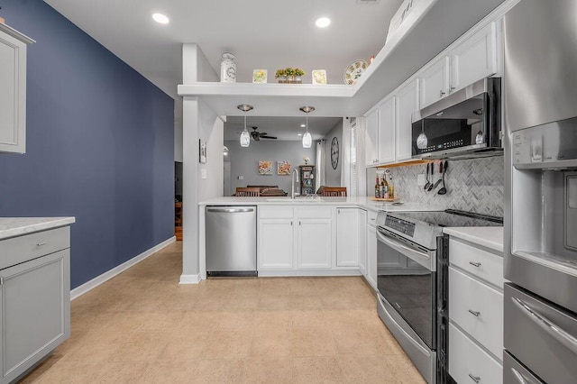 kitchen with appliances with stainless steel finishes, a sink, a ceiling fan, light countertops, and backsplash