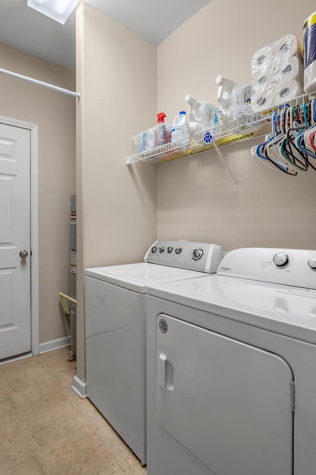 laundry room with separate washer and dryer and baseboards