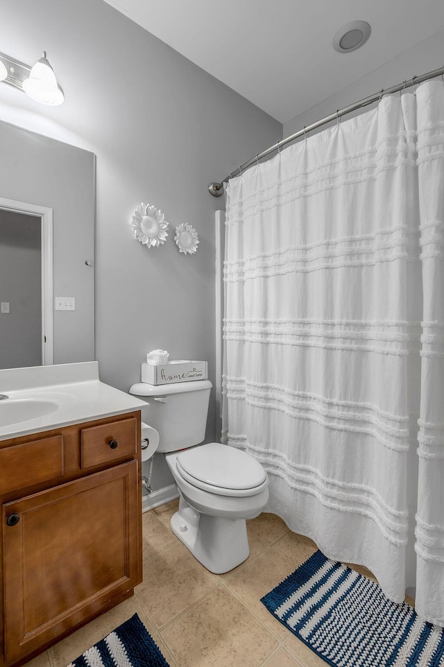 full bath featuring toilet, vanity, and tile patterned flooring
