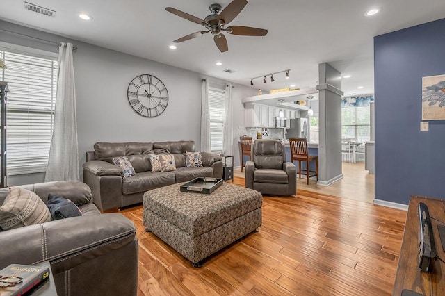 living room featuring ceiling fan, light wood-type flooring, recessed lighting, rail lighting, and baseboards