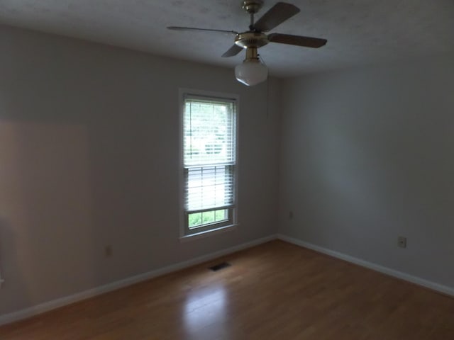 empty room with light wood-type flooring, baseboards, and ceiling fan