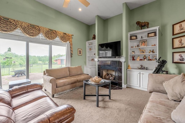 living area with a fireplace, ceiling fan, and light carpet