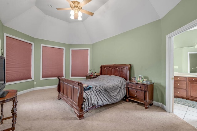bedroom featuring lofted ceiling, light colored carpet, ensuite bathroom, ceiling fan, and baseboards