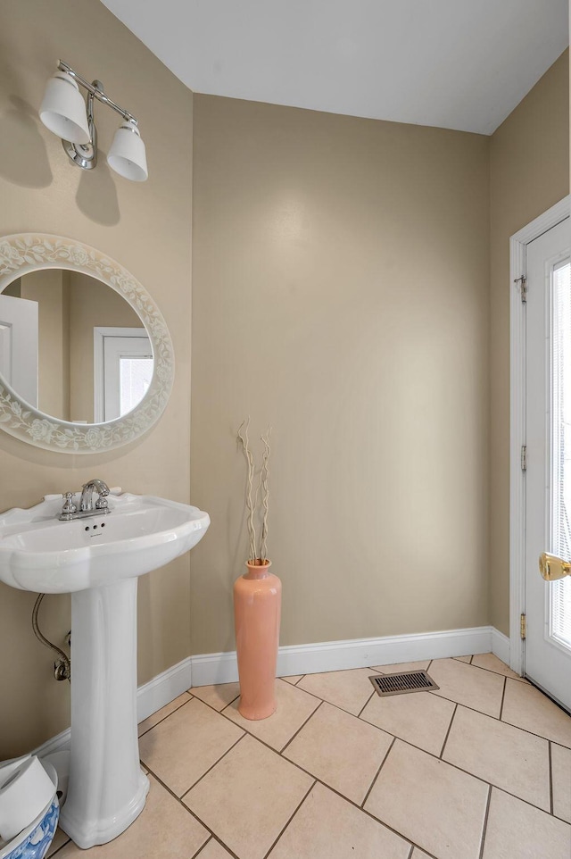 bathroom featuring tile patterned flooring, healthy amount of natural light, and baseboards