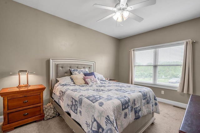 bedroom with light colored carpet, baseboards, and a ceiling fan