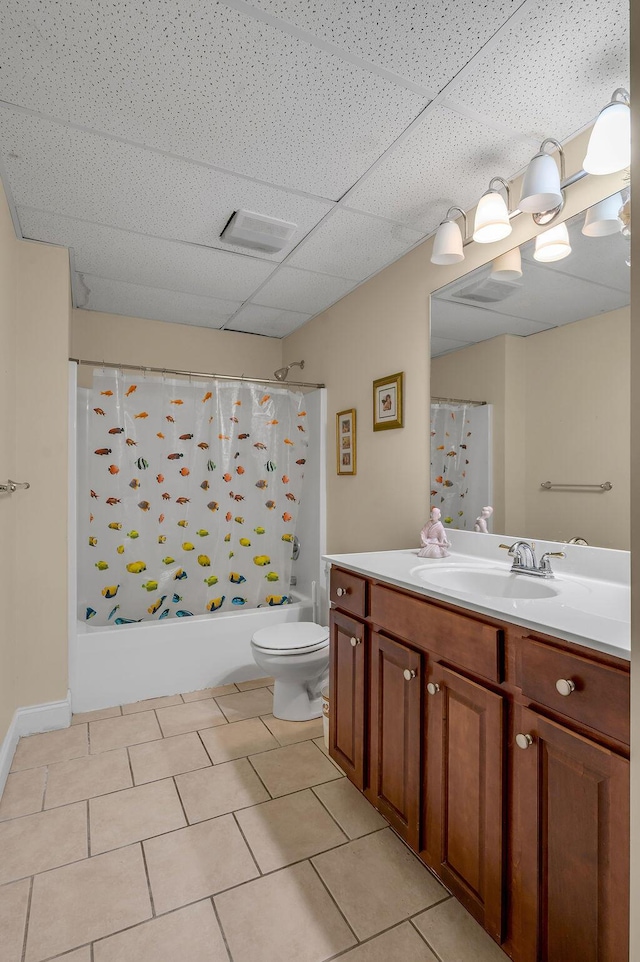 full bath featuring shower / tub combo with curtain, tile patterned flooring, vanity, toilet, and a paneled ceiling