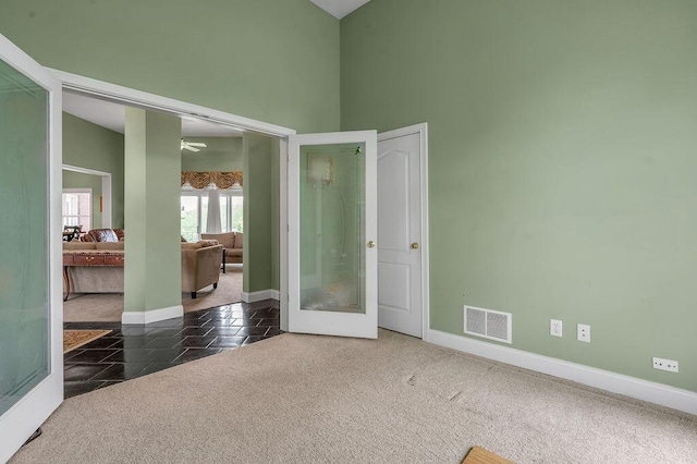empty room featuring baseboards, carpet, a high ceiling, and ceiling fan