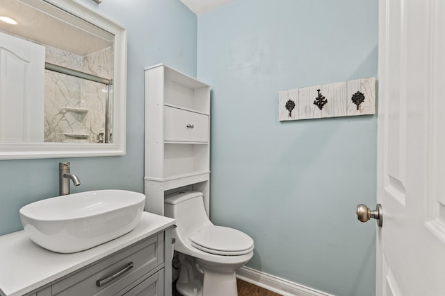 bathroom with vanity, toilet, wood finished floors, and a shower