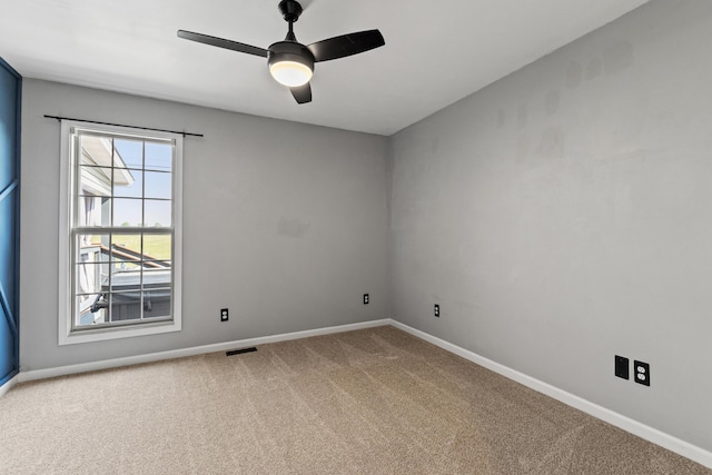 spare room with carpet, baseboards, and ceiling fan