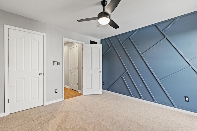 unfurnished bedroom featuring carpet, baseboards, and a ceiling fan