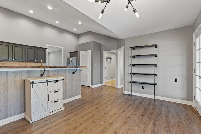 kitchen with freestanding refrigerator, baseboards, wood finished floors, recessed lighting, and a peninsula