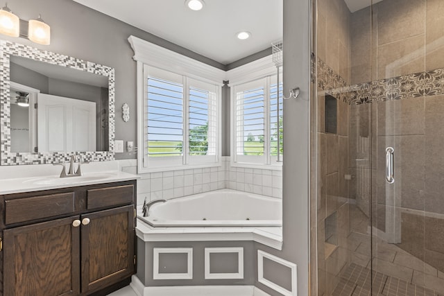 full bathroom featuring a stall shower, a jetted tub, vanity, and recessed lighting