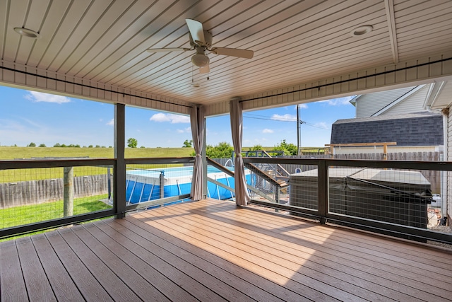 wooden terrace with ceiling fan and fence
