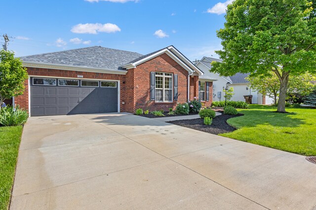 view of front of house with brick siding, a front yard, an attached garage, and driveway