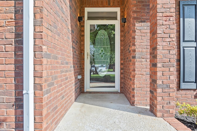 doorway to property with brick siding