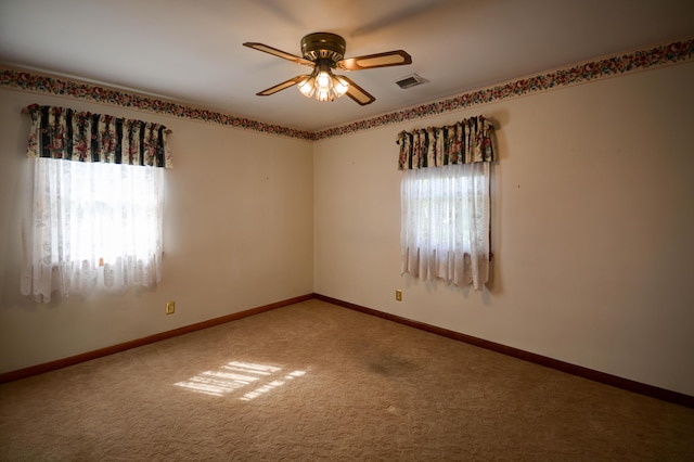 spare room featuring ceiling fan, carpet, and baseboards