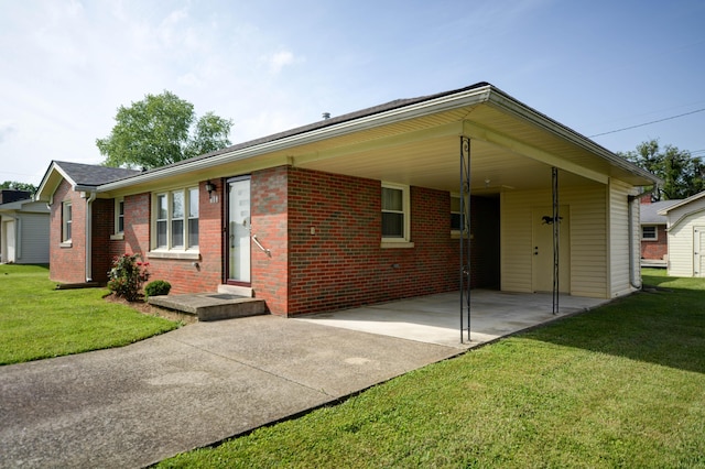 single story home featuring concrete driveway, a front yard, an attached carport, and brick siding