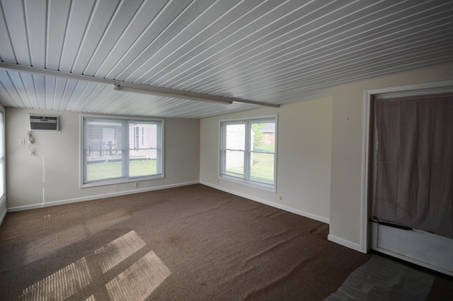 empty room with baseboards, a wall mounted air conditioner, and dark carpet