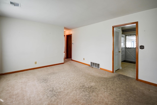 carpeted empty room featuring baseboards