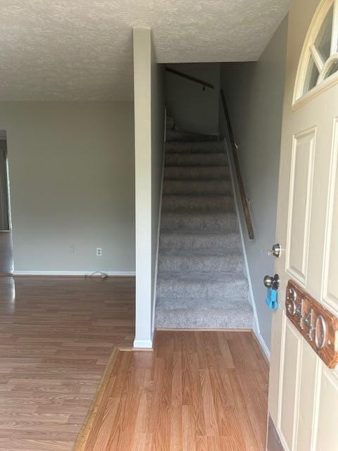 3440 Sutherland Dr, Lexington, KY 40517 - stairs with a textured ceiling, wood finished floors, and baseboards