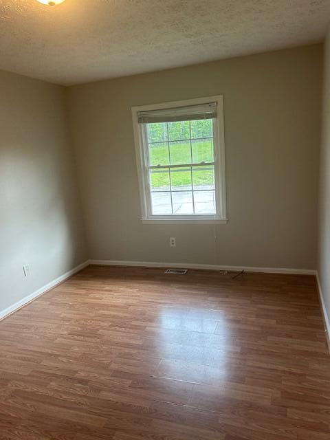 3440 Sutherland Dr, Lexington, KY 40517 - unfurnished room with wood finished floors, baseboards, and a textured ceiling