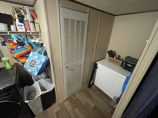 laundry room with a textured ceiling, a heating unit, and dark wood-style flooring