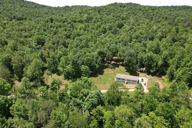 aerial view of property and surrounding area with a heavily wooded area
