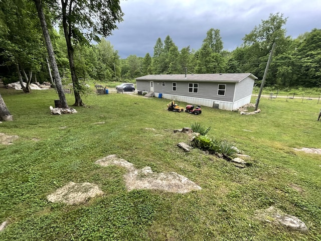 view of grassy yard featuring a view of trees
