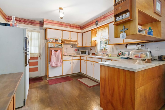 301 Vaught St, Somerset, KY 42501 - kitchen with freestanding refrigerator, oven, light countertops, and dark wood-type flooring