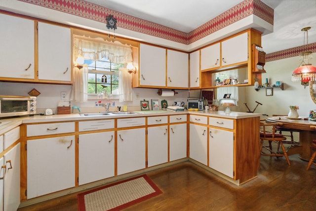 301 Vaught St, Somerset, KY 42501 - kitchen with a sink, light countertops, dark wood finished floors, hanging light fixtures, and white cabinets
