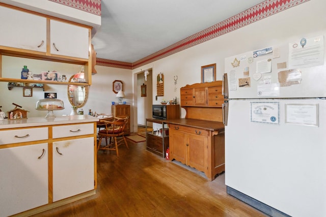 301 Vaught St, Somerset, KY 42501 - kitchen with freestanding refrigerator, black microwave, wood finished floors, light countertops, and crown molding