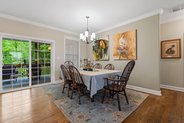 dining room with a chandelier, crown molding, baseboards, and wood finished floors
