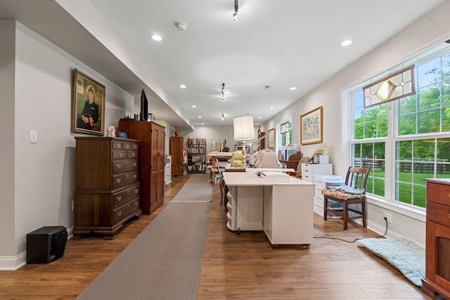 kitchen featuring wood finished floors, light countertops, open floor plan, recessed lighting, and baseboards