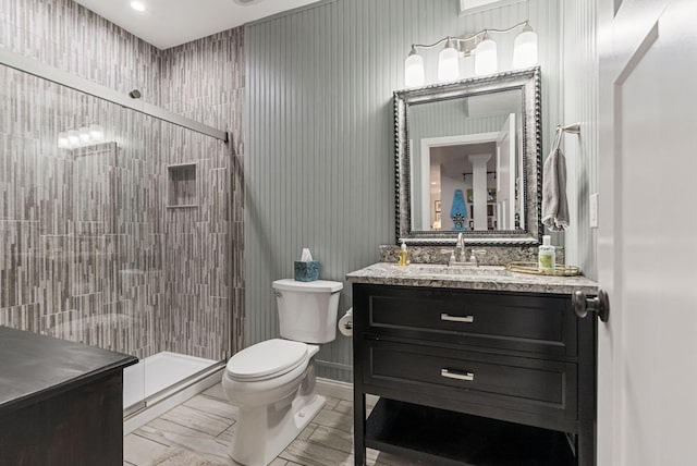 bathroom featuring a stall shower, toilet, and vanity
