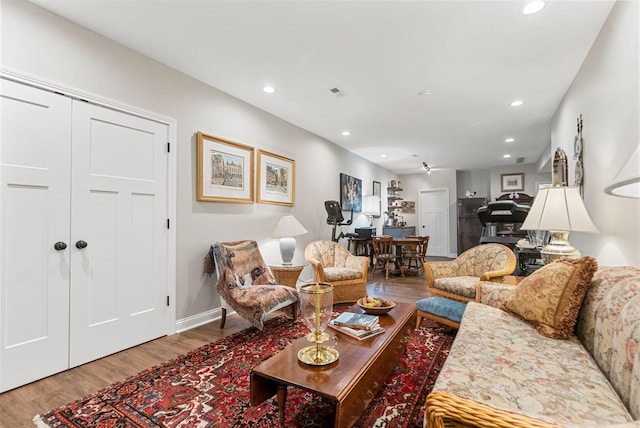 living area featuring wood finished floors, recessed lighting, and baseboards
